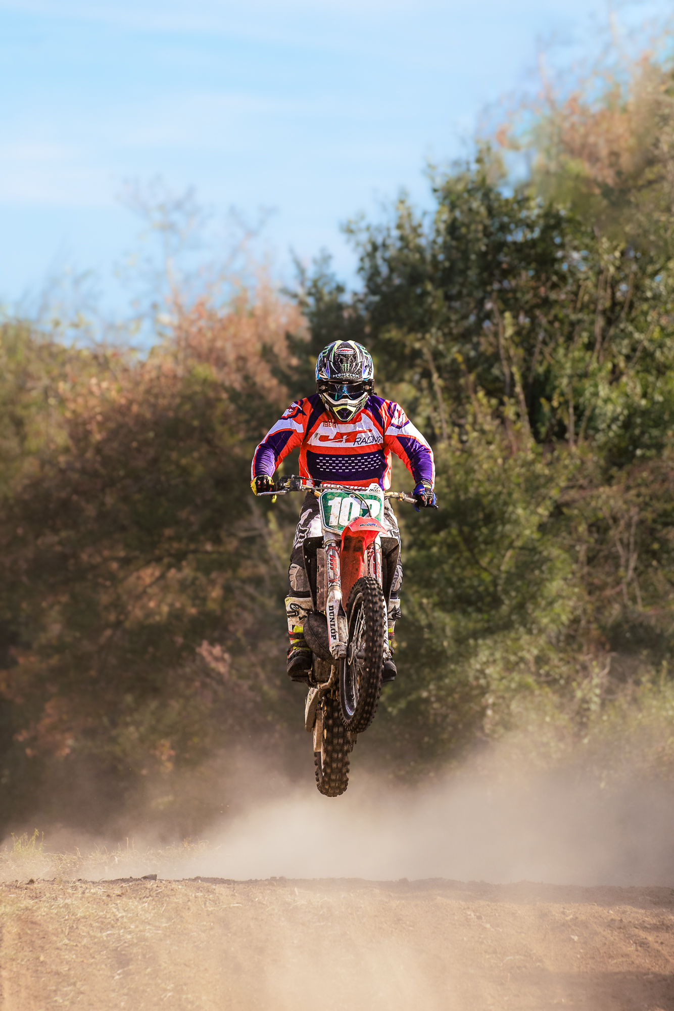 Pilote de motocross en plein saut dans un nuage de poussière, photographe de sport Clermont-Ferrand, Lucile Duvert Photographe Auvergne